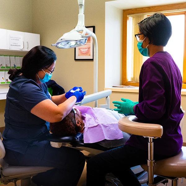 Dr. Ona and an assistant caring for a patient in a treatment room